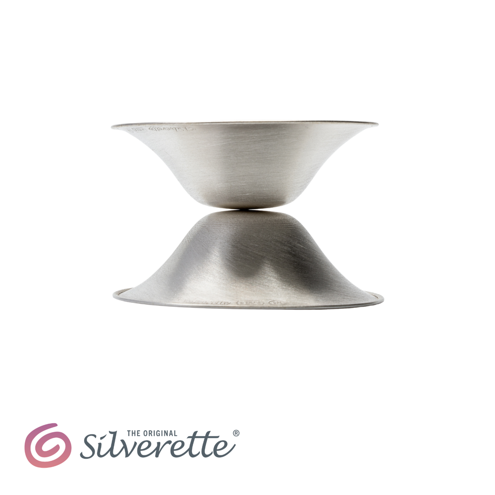 Side profile of two Silverette nursing cups stacked base to base, showing their slim low-profile shape